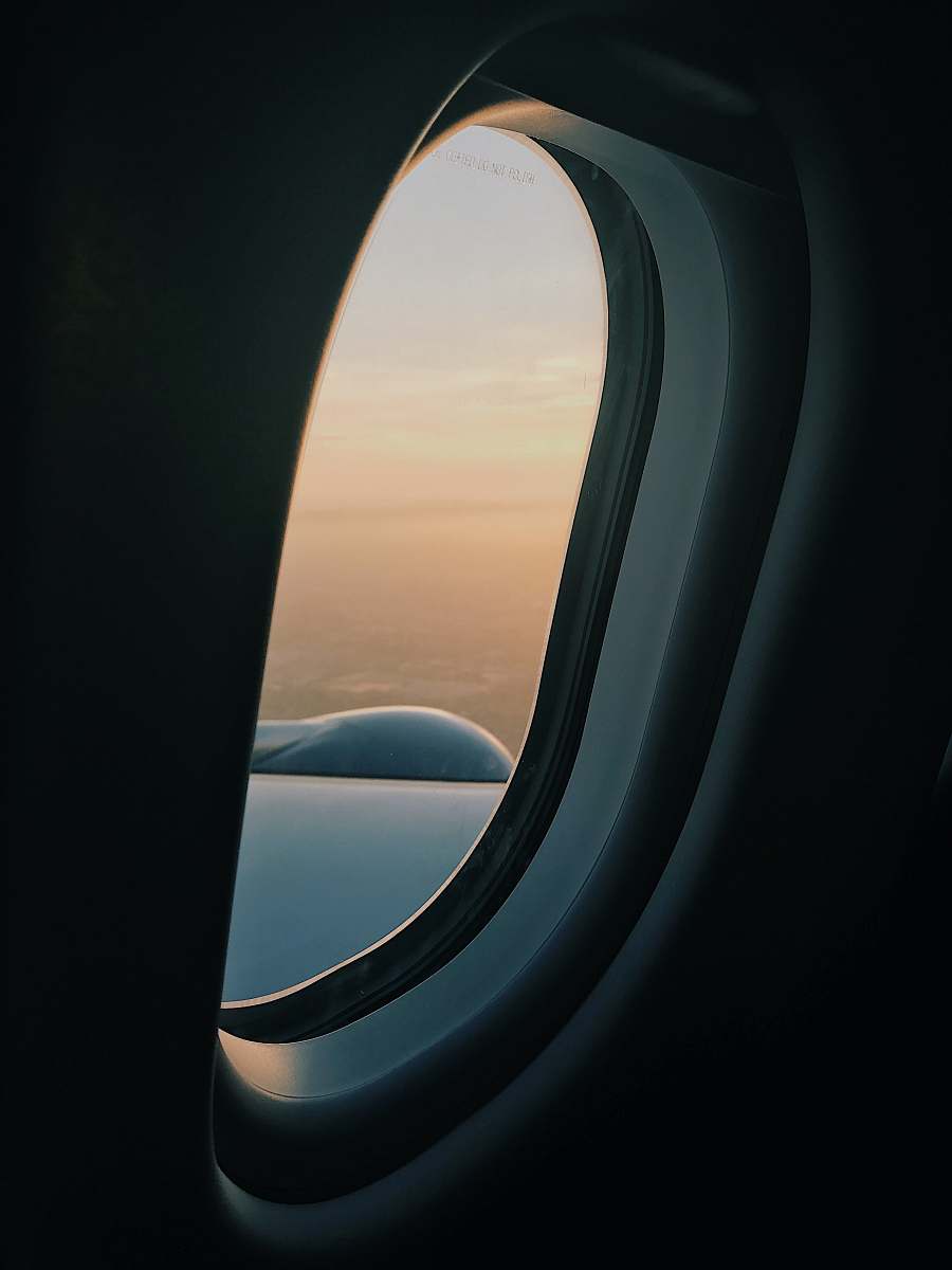 iphone backgrounds person inside plane at high altitude taking picture of left wing during daytime window